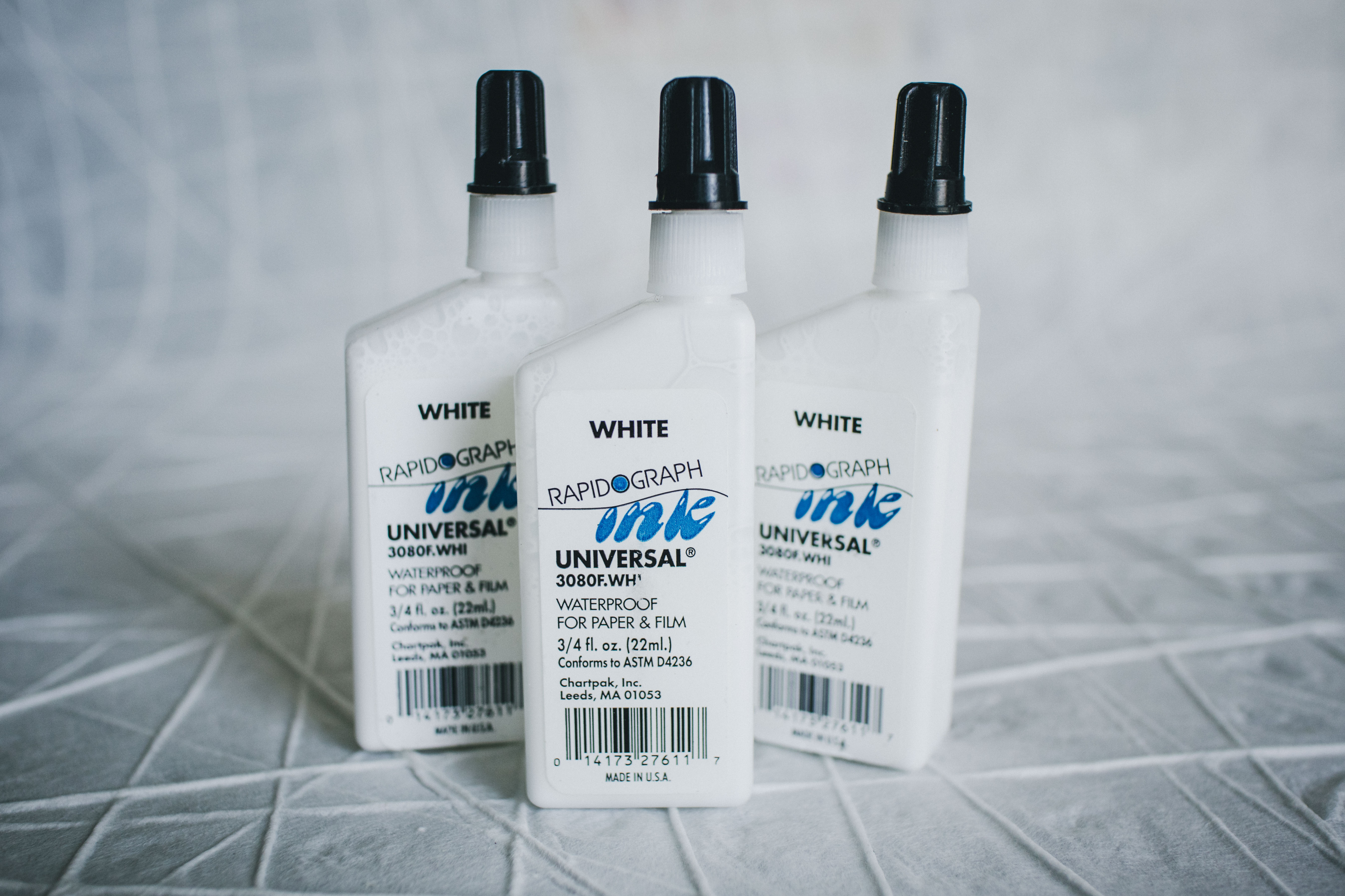 Rapidograph-universal-white-waterproof-ink Closeup of three bottles of Rapidograph universal waterproof white ink on a table