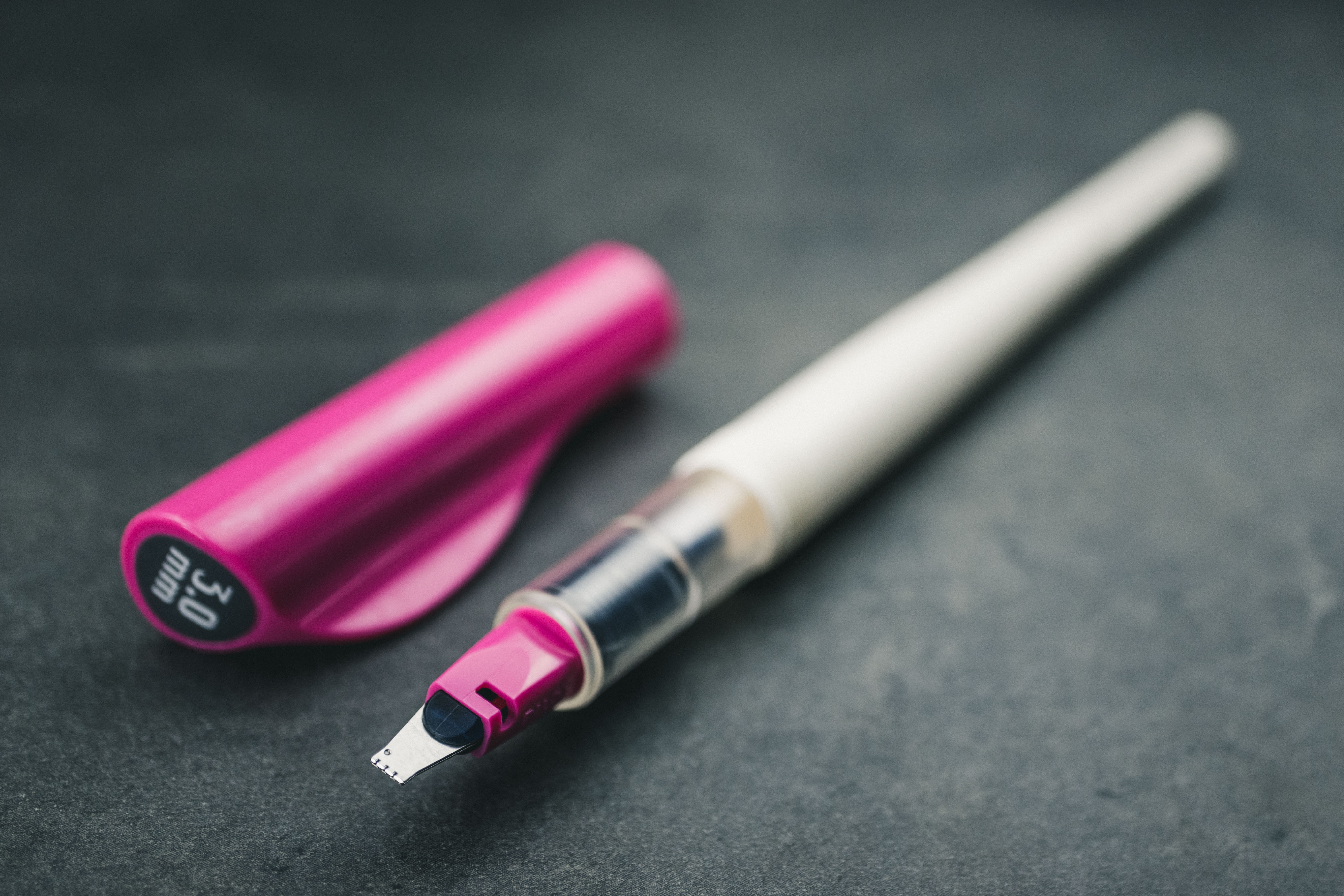Pilot-parrallel-3mm-pink-pen-cap 3mm pink pilot parallel assembled pen and cap sitting on a grey counter